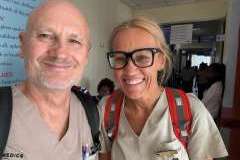 kobieta z mężczyzną w uniformach medycznych stoją na korytarzu i uśmiechają się