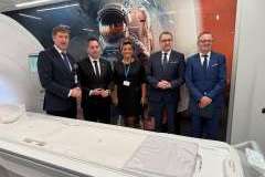 pięć osób stoi za rezonansem magnetycznym, za nimi tapeta z wizerunkiem kosmosu i kosmonauty