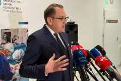 mężczyzna w okularach przemawia do mikrofonu