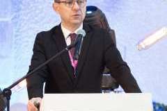 mężczyzna stojący przy mównicy mówi przez mikrofon