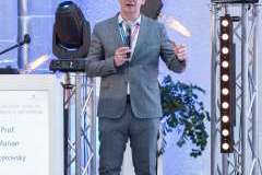 mężczyzna stojący przy mównicy i mówiąca przez mikrofon