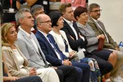 Uroczystość absolutorium. Zaproszeni goście siedzą na auli. Atmosfera jest uroczysta.