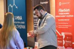 kobieta rozmawia z mężczyzna przy stoisku promocyjnym