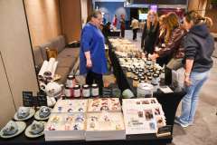 grupa kobiet rozmawia przy stoisku promocyjnym