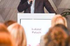 uczestnicy konferencji słuchają mężczyzny stojącego przy mównicy