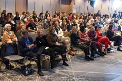 uczestnicy konferencji siedzą w sali audytoryjnej