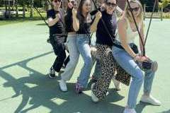 Cztery młode kobiety i jeden mężczyzna na huśtawce w parku