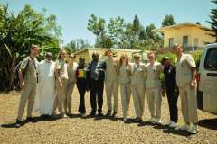 Grupa stojących medyków, w tle budynki i egzotyczne drzewa