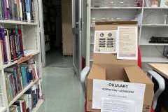 Karton na zbiórkę okularów i leków postawiony w bibliotece