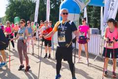 grupa osób w strojach sportowych trzymają w rękach kijki nordic walking