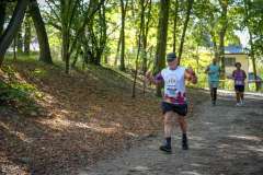 grupa biegnących osób w sportowych strojach w parku