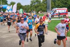 grupa biegnących osób w sportowych strojach