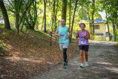 dwie biegnące osoby w sportowych strojach w parku