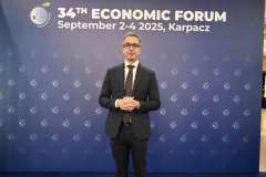 Jeden mężczyzna stoi na tle ścianki forum