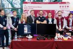 grupa osób pozujących do zdjęcia na tle ścianki promocyjnej