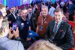 uczestnicy spotkania na auli, jeden robi zdjęcie gościowi